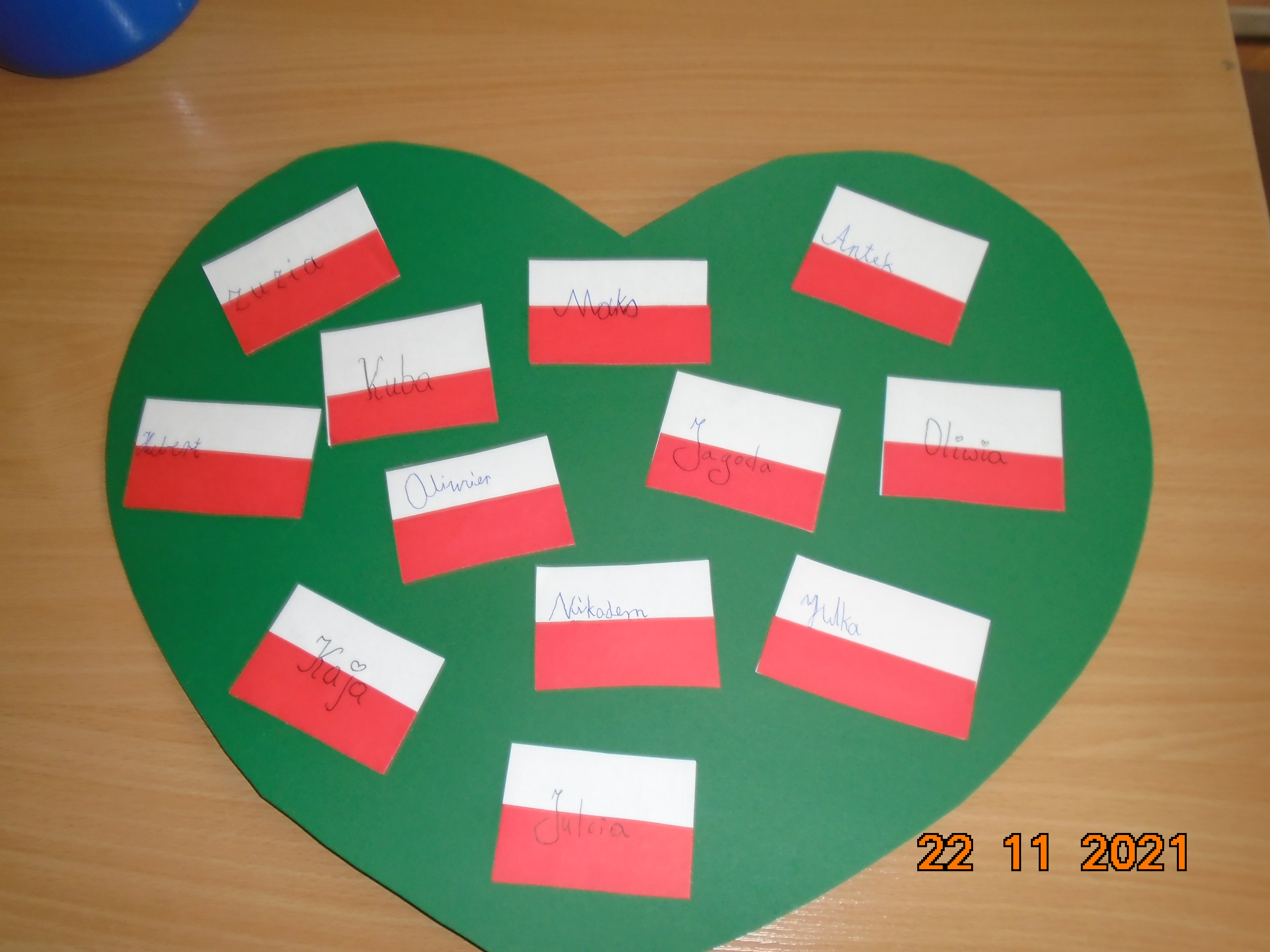 Plakat w kształcie serca z flagami Polski