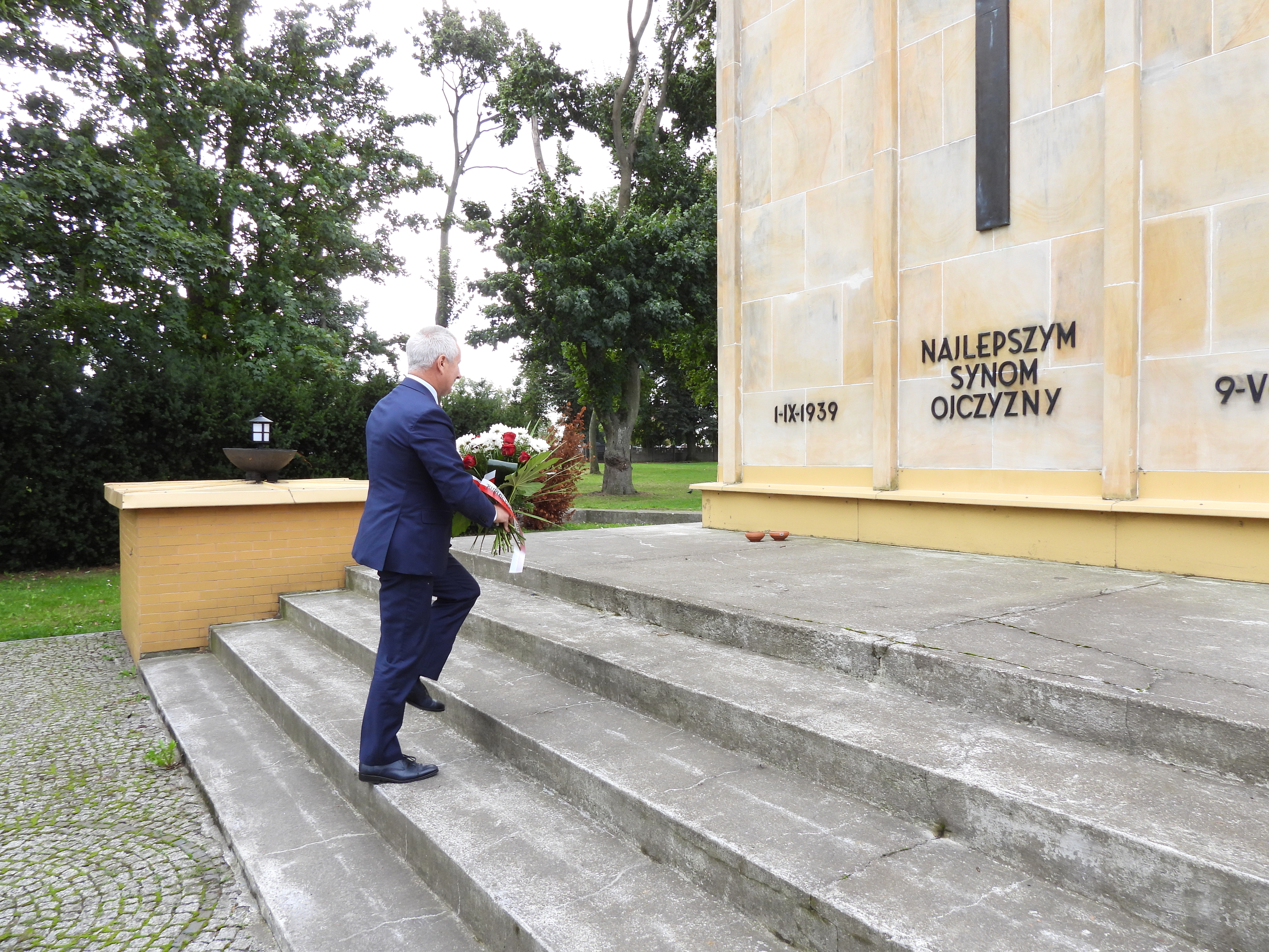 Burmistrz Tadeusz Kowalski składa wiązankę kwiatów przy mauzoleum pomordowanych przy ul. Chopina w Tucholi
