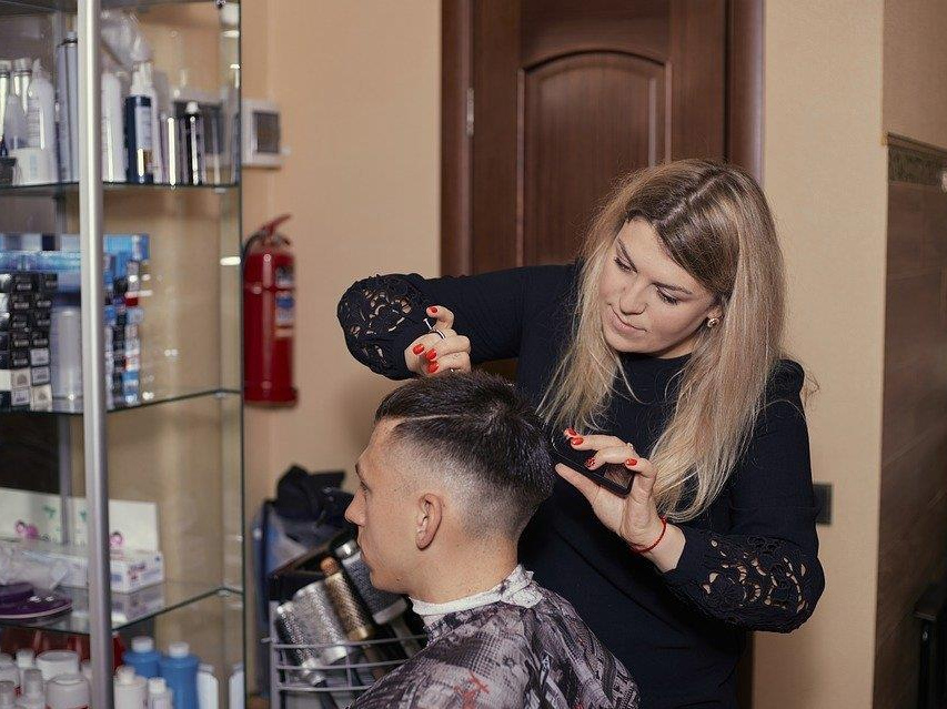 Na zdjęciu fryzjerka obcinająca włosy mężczyźnie, fot. Pixabay