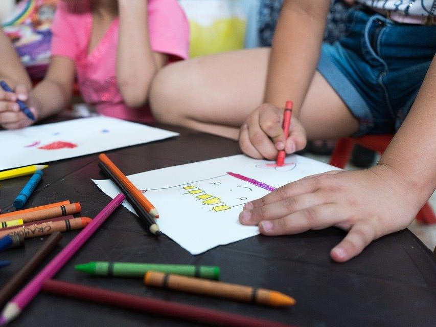 Na zdjęciu dzieci podczas rysowania na kartkach, fot. Pixabay