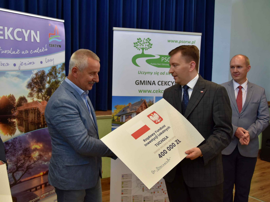 Minister Łukasz Schreiber wręcza burmistrzowi Tucholi symboliczny czek