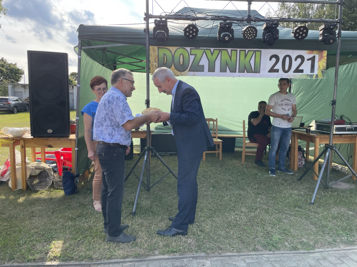 Burmistrz odbiera chleb dożynkowy z rąk sołtysa Małej Komorzy