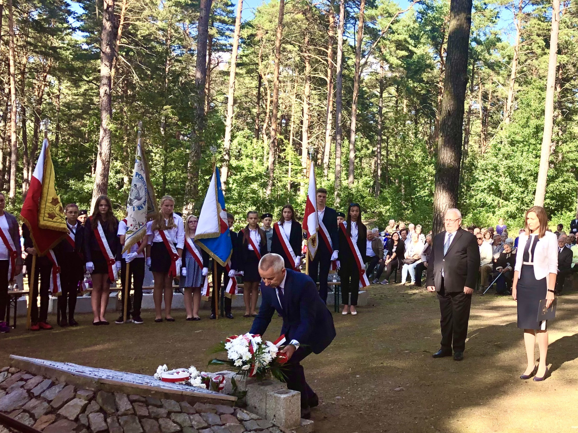 Burmistrz Tadeusz Kowalski składa wiązankę kwiatów przy pomniku