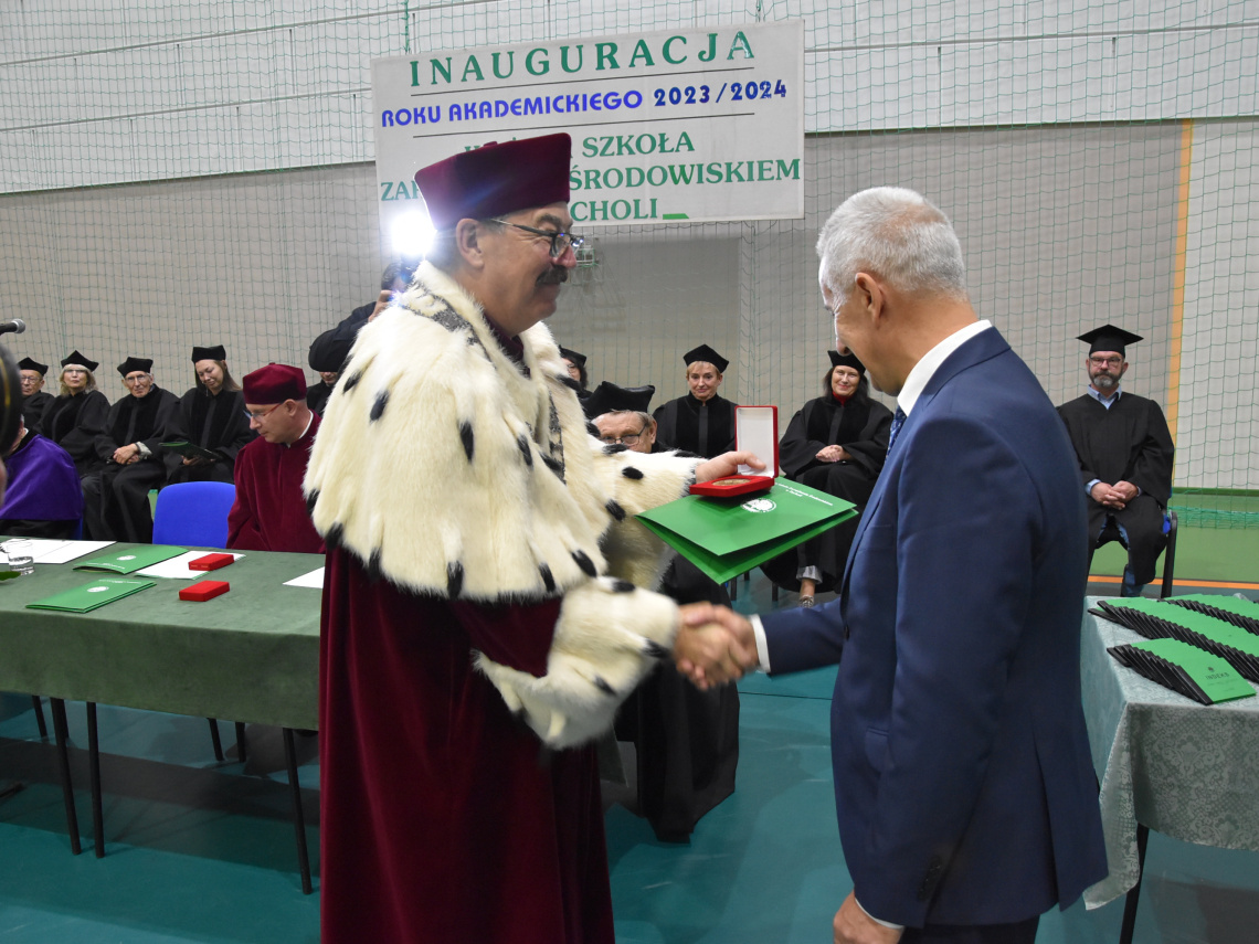 Rektor uczelni wręcza medal burmistrzowi Tucholi