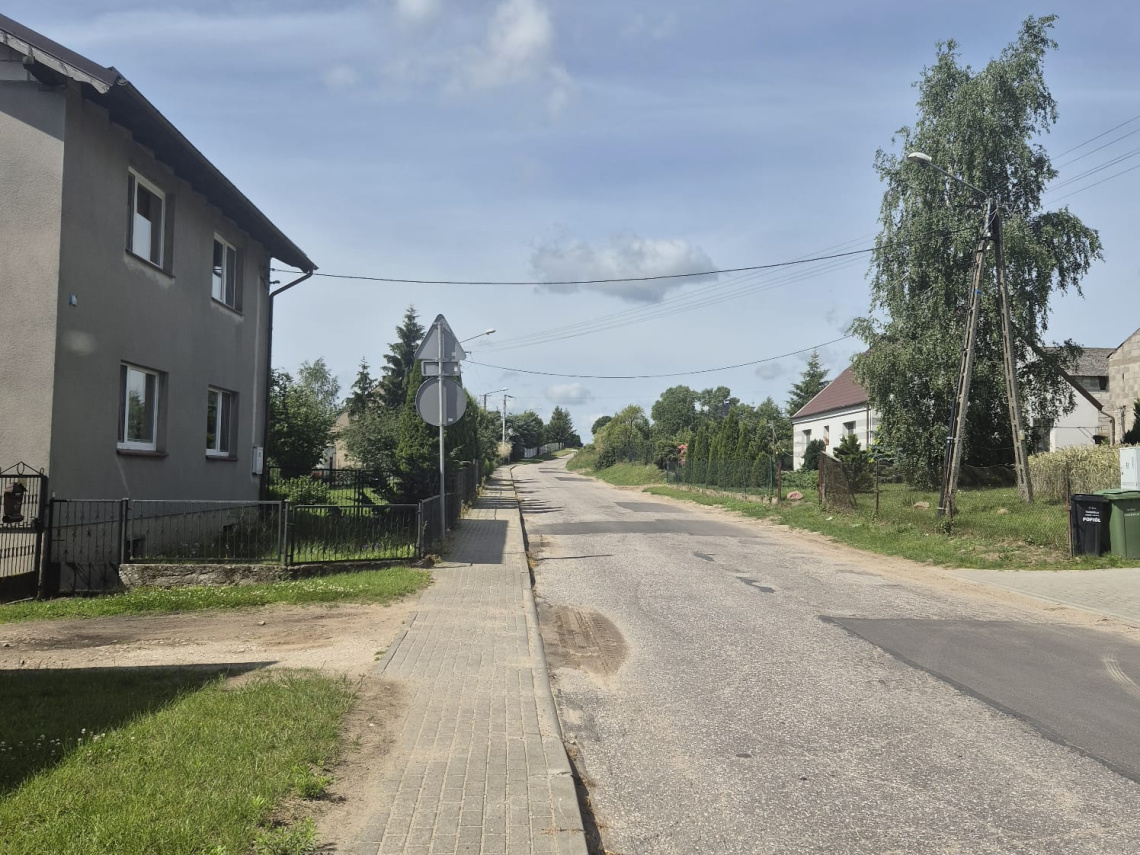 Zdjęcie przedstawia ulicę i domy