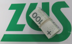 na zdjęciu widnieje logo ZUS oraz zwinięty rulon pieniędzy