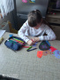 Dzieci przygotowują papierowe serduszka z życzeniami
