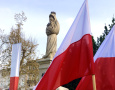 na zdjęciu widnieje flaga Polski oraz pomnik Matki Boskiej 
