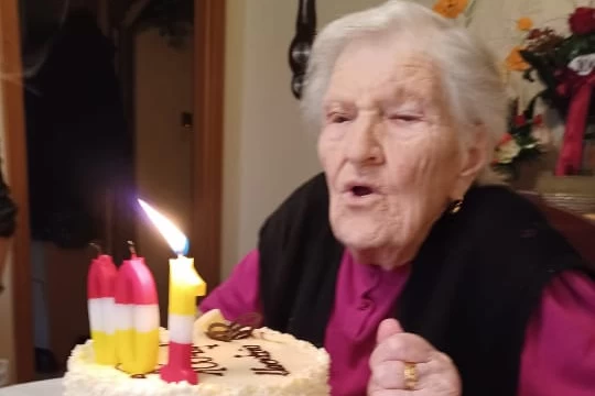 Pani Antonina zdmuchuje świeczki z tortu, fot. archiwum rodzinne